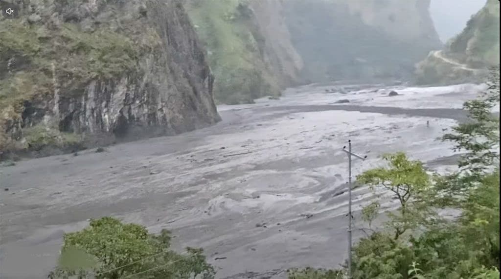 Flooded Budhi Gandaki river carrying heavy debris and muddy water along rocky gorge in Gorkha