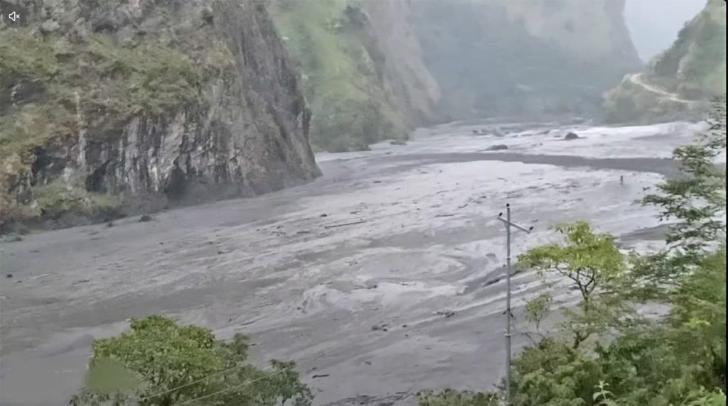 Flooded Budhi Gandaki river carrying heavy debris and muddy water along rocky gorge in Gorkha